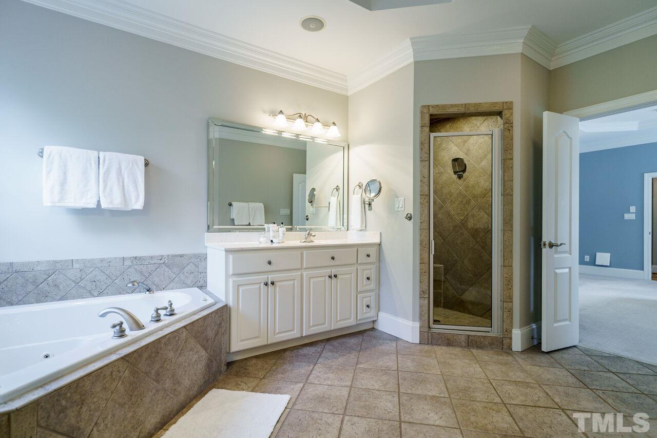 4813 Patton Ridge Court Raleigh, NC 27612 - Photo 17 of 30 a spacious bathroom with a tub sink and mirror