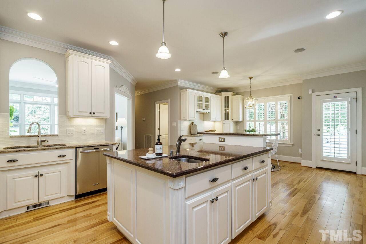 4813 Patton Ridge Court Raleigh, NC 27612 - Photo 10 of 30 a kitchen with kitchen island granite countertop a sink cabinets and wooden floor