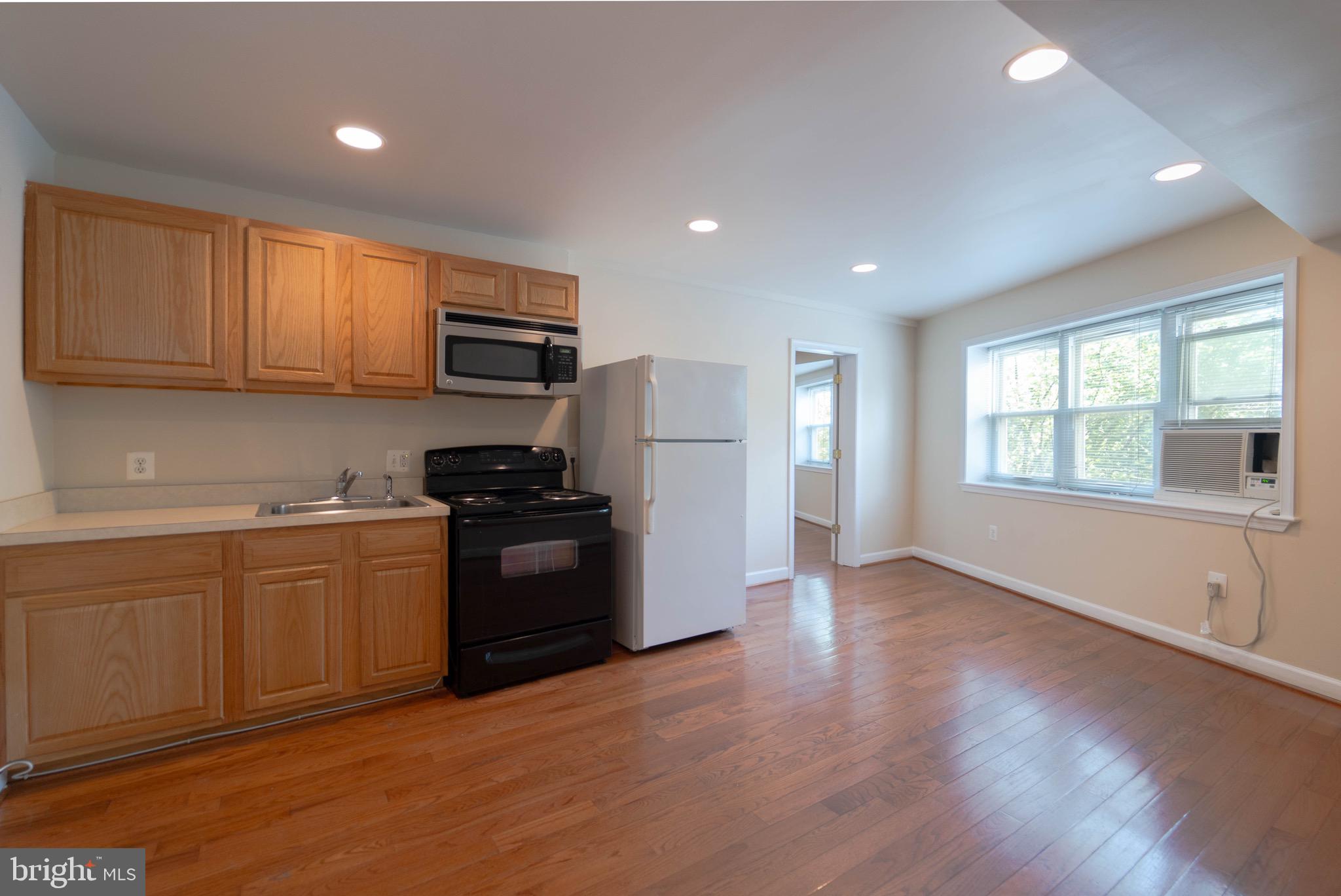 444 Rhode Island Avenue Northwest, Unit 302 Washington, DC 20001 - Photo 2 of 13 a kitchen with granite countertop wooden floors and stainless steel appliances