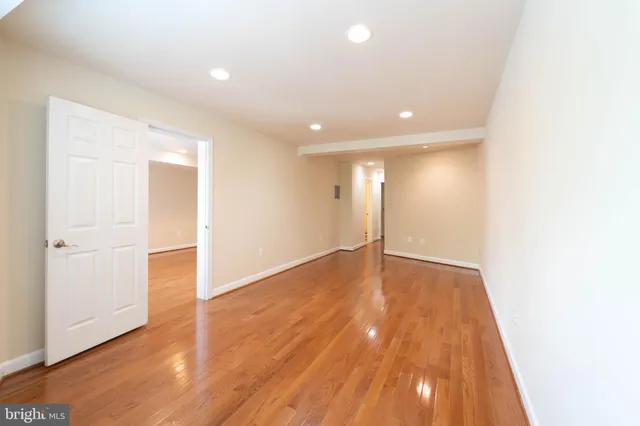 a view of an empty room with wooden floor