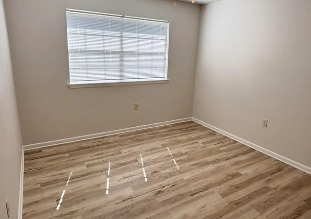 a view of a room with wooden floor and windows