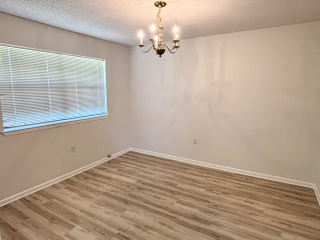 a view of a room with wooden floor and chandelier