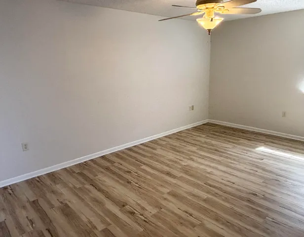 a view of a room with wooden floor and a window