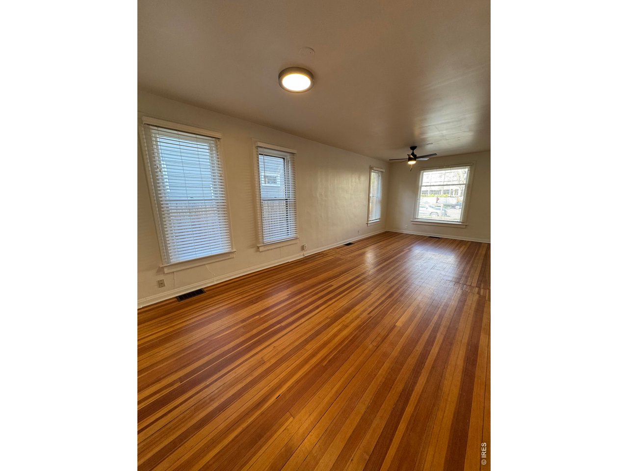 612 South Howes Street Fort Collins, CO 80521 - Photo 5 of 18 a view of an empty room with wooden floor and a window