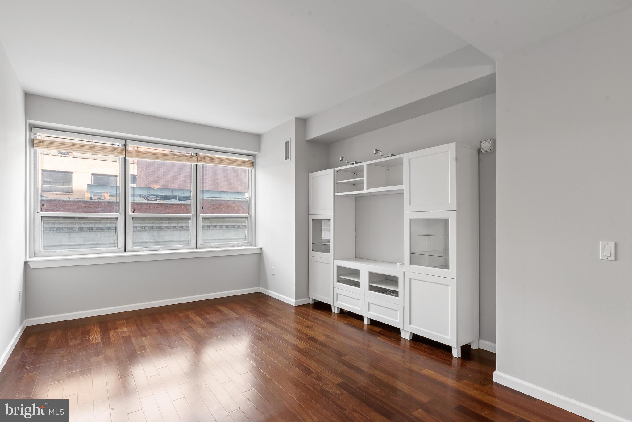 1425 Locust Street, Unit 9E Philadelphia, PA 19102 - Photo 3 of 15 an empty room with wooden floor and windows
