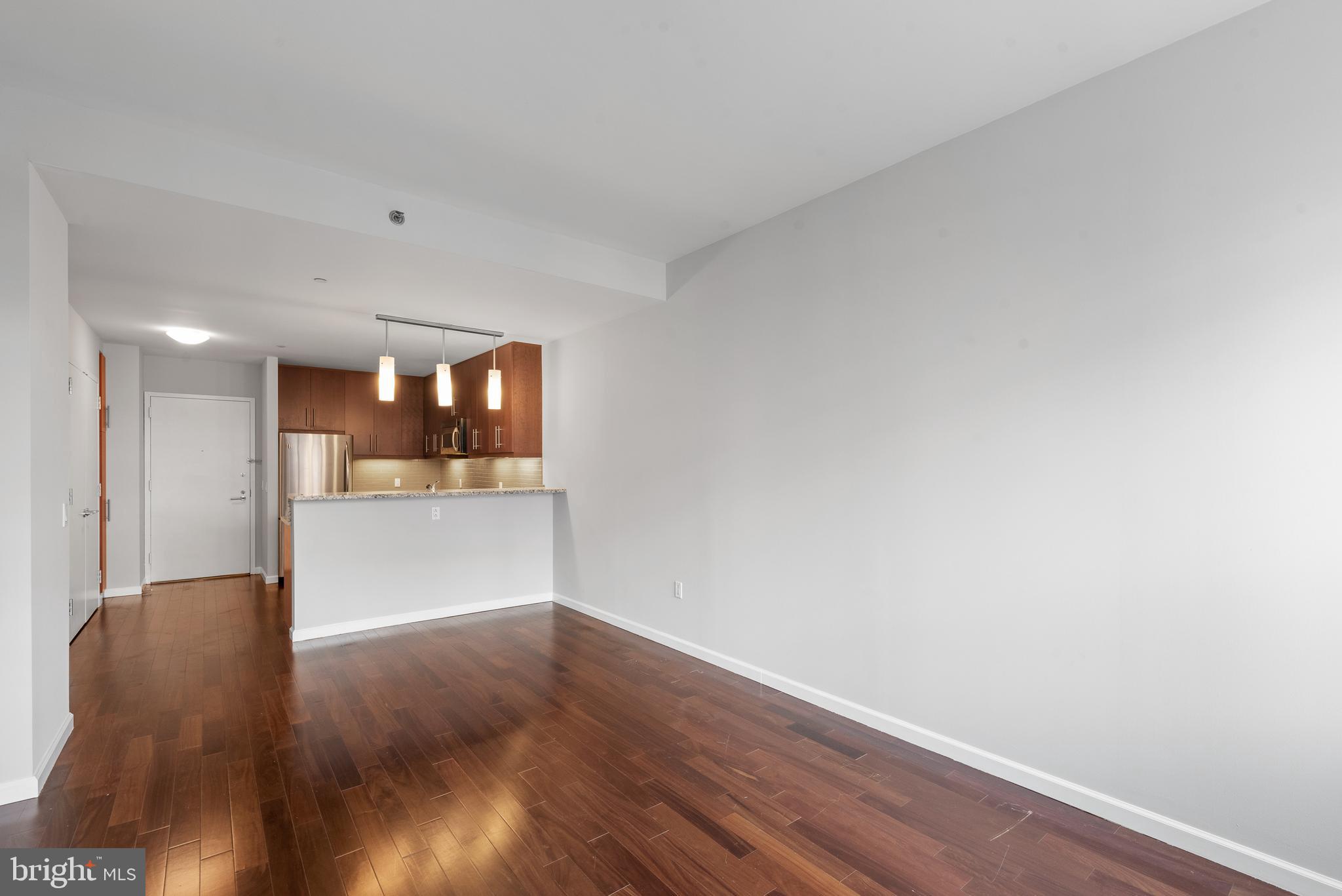 1425 Locust Street, Unit 9E Philadelphia, PA 19102 - Photo 6 of 15 a view of a room with wooden floor and kitchen