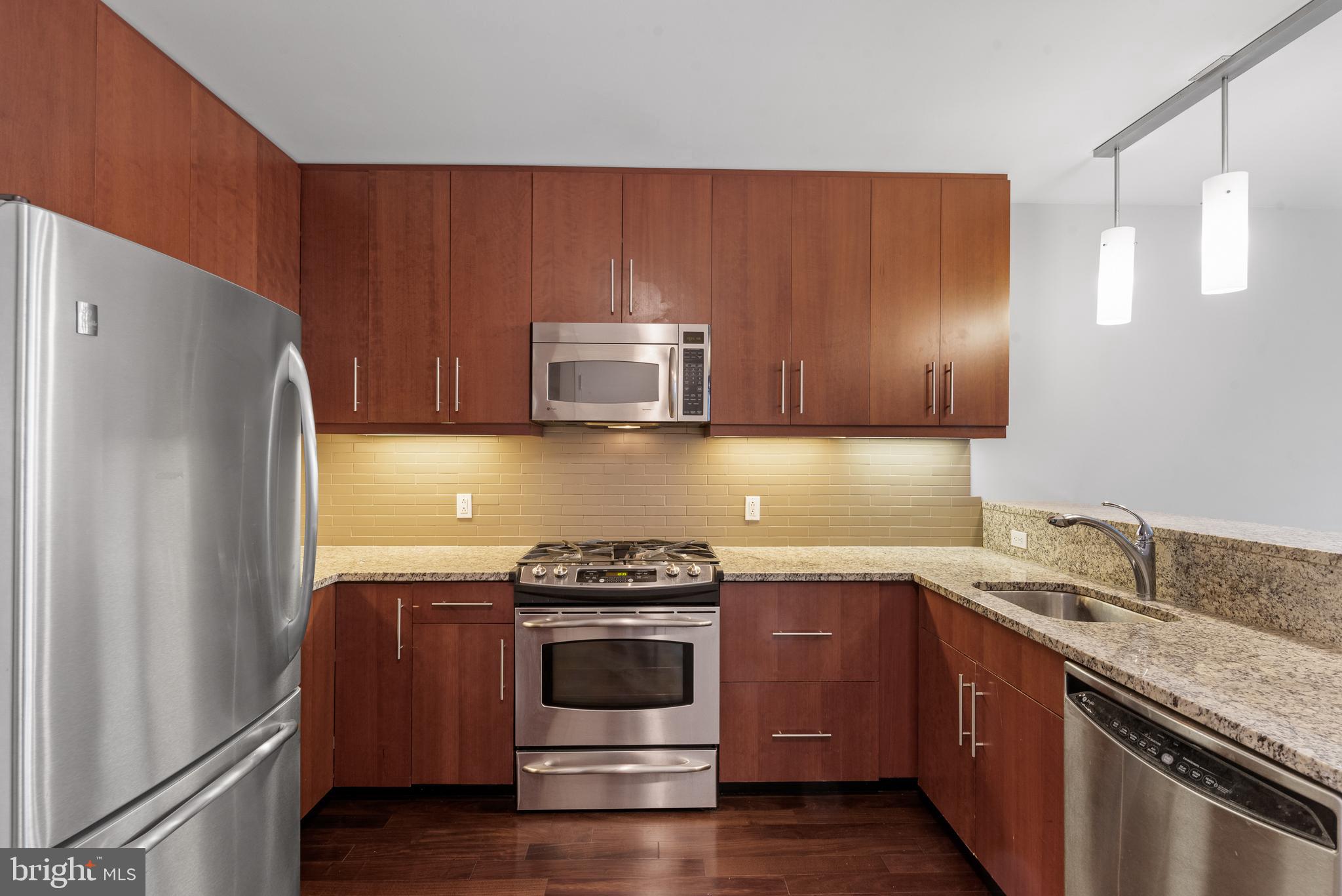 1425 Locust Street, Unit 9E Philadelphia, PA 19102 - Photo 7 of 15 a kitchen with stainless steel appliances granite countertop a stove a refrigerator and a sink