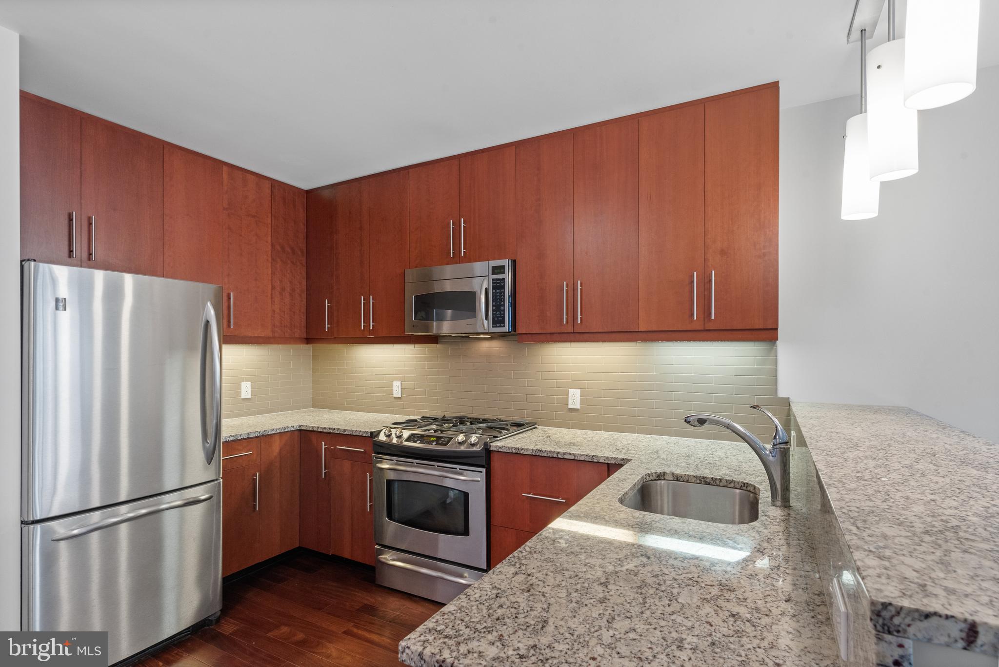 1425 Locust Street, Unit 9E Philadelphia, PA 19102 - Photo 9 of 15 a kitchen with stainless steel appliances granite countertop a refrigerator sink and stove