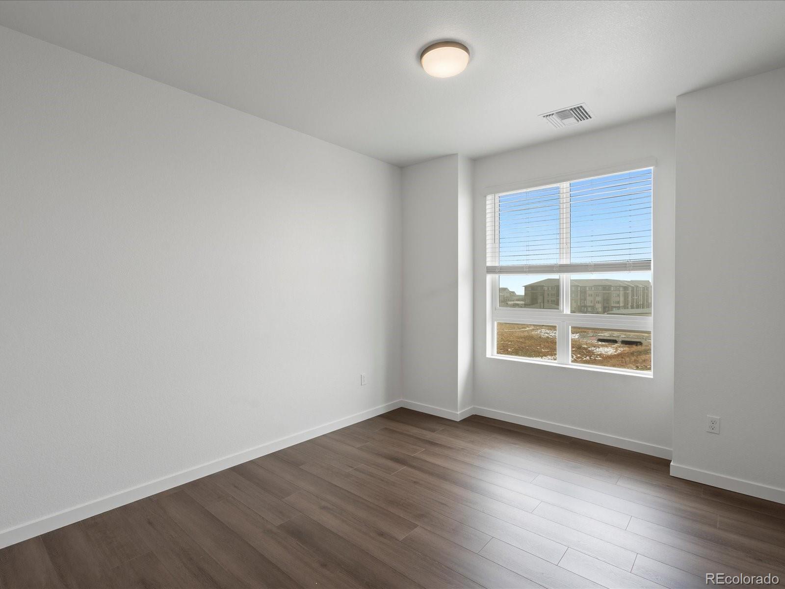 6153 North Ceylon Street, Unit 304 Denver, CO 80249 - Photo 12 of 24 an empty room with wooden floor and windows