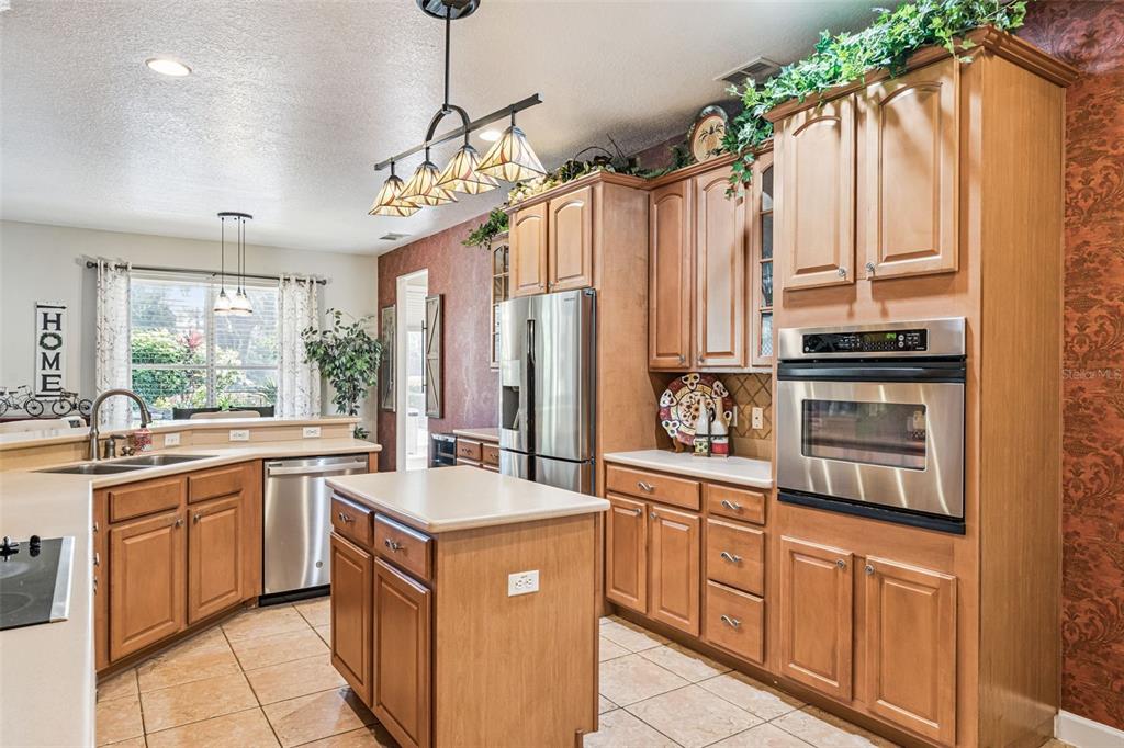 3304 Beazer Drive Ocoee, FL 34761 - Photo 18 of 53 a kitchen with stainless steel appliances a sink stove and cabinets