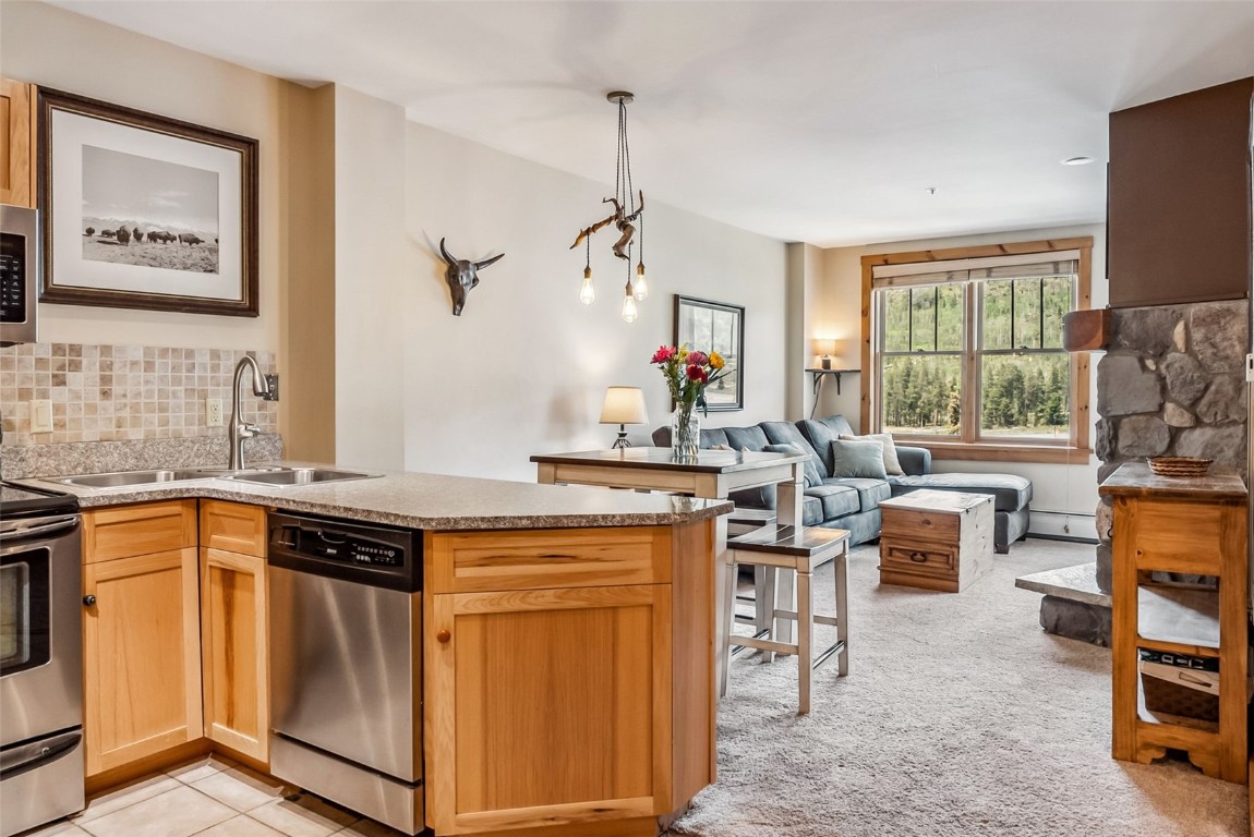 100 Dercum Square, Unit 8386 Keystone, CO 80435 - Photo 1 of 34 a open kitchen with stainless steel appliances granite countertop a stove top oven a sink a dining table and chairs with the front door