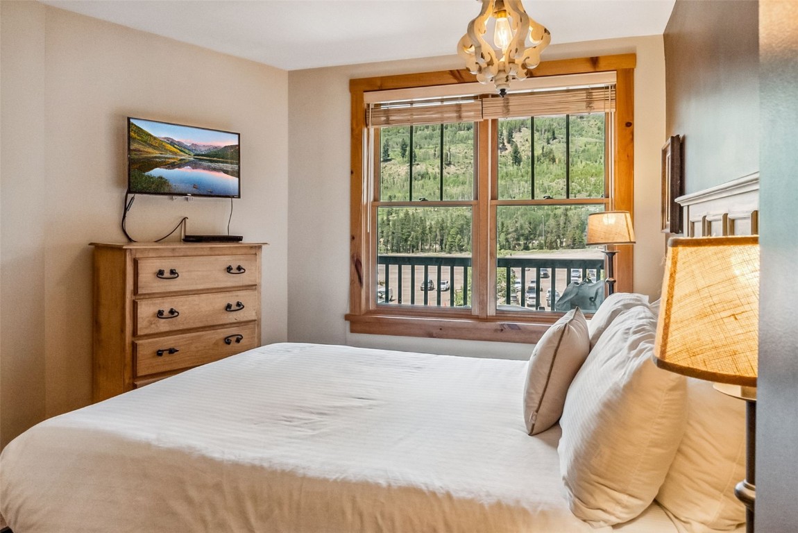 100 Dercum Square, Unit 8386 Keystone, CO 80435 - Photo 23 of 34 a bedroom with a bed and a chandelier