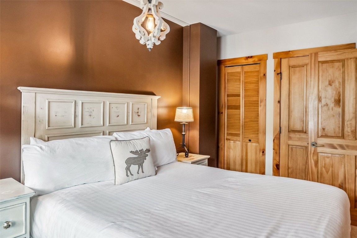 100 Dercum Square, Unit 8386 Keystone, CO 80435 - Photo 24 of 34 a bedroom with a large bed and wooden floor