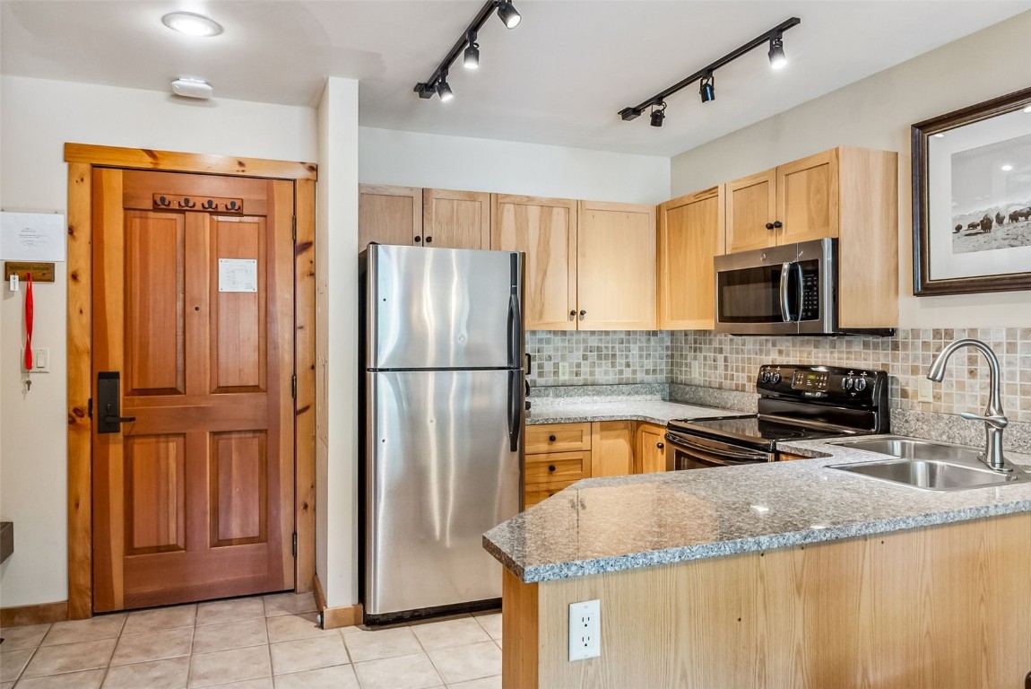 100 Dercum Square, Unit 8386 Keystone, CO 80435 - Photo 3 of 34 a kitchen with granite countertop a refrigerator and a sink