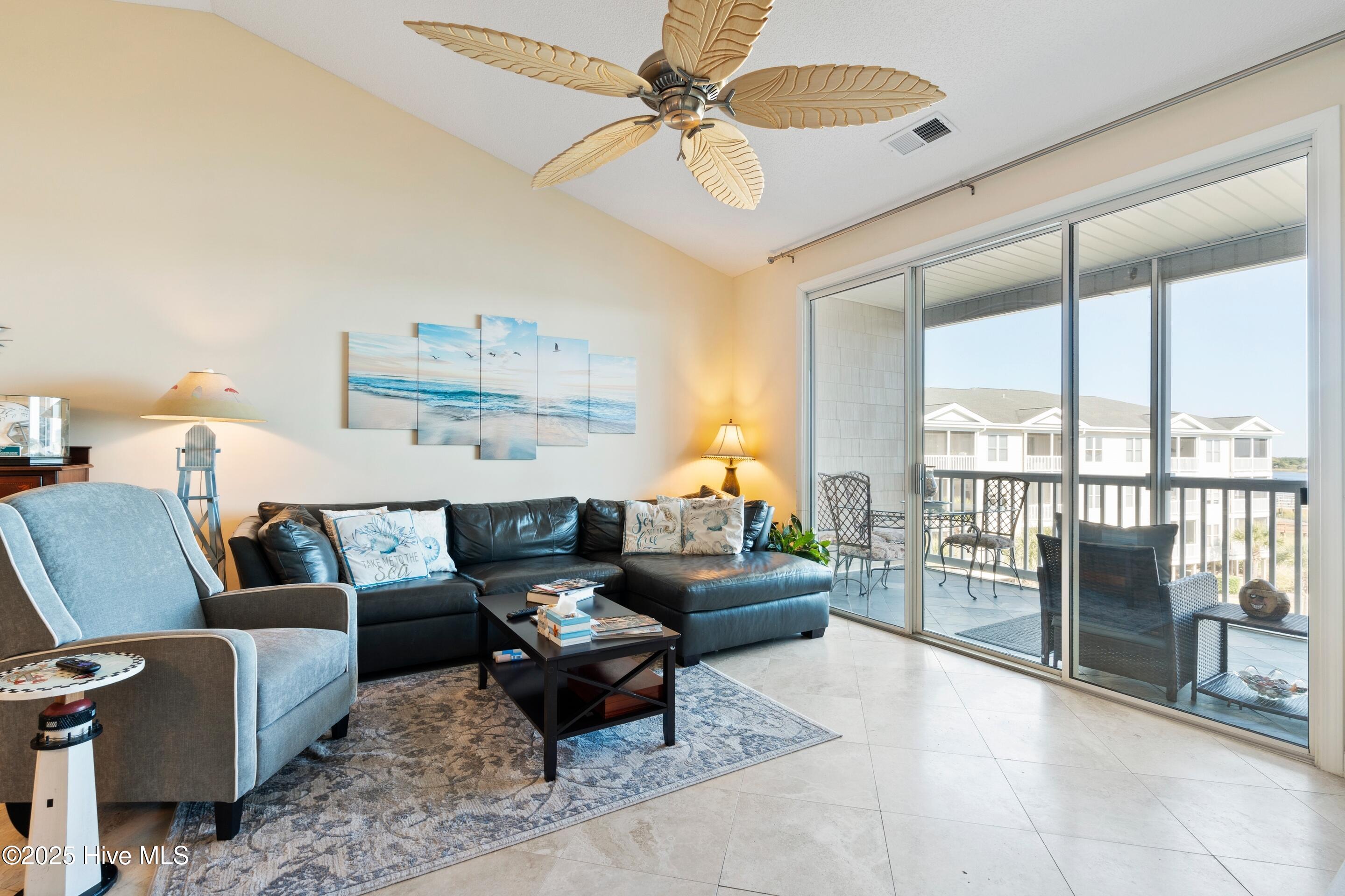 1135 Park Road Southwest, Unit 2304 Sunset Beach, NC 28468 - Photo 15 of 45 Living room with vaulted ceiling, fan and travertine floors