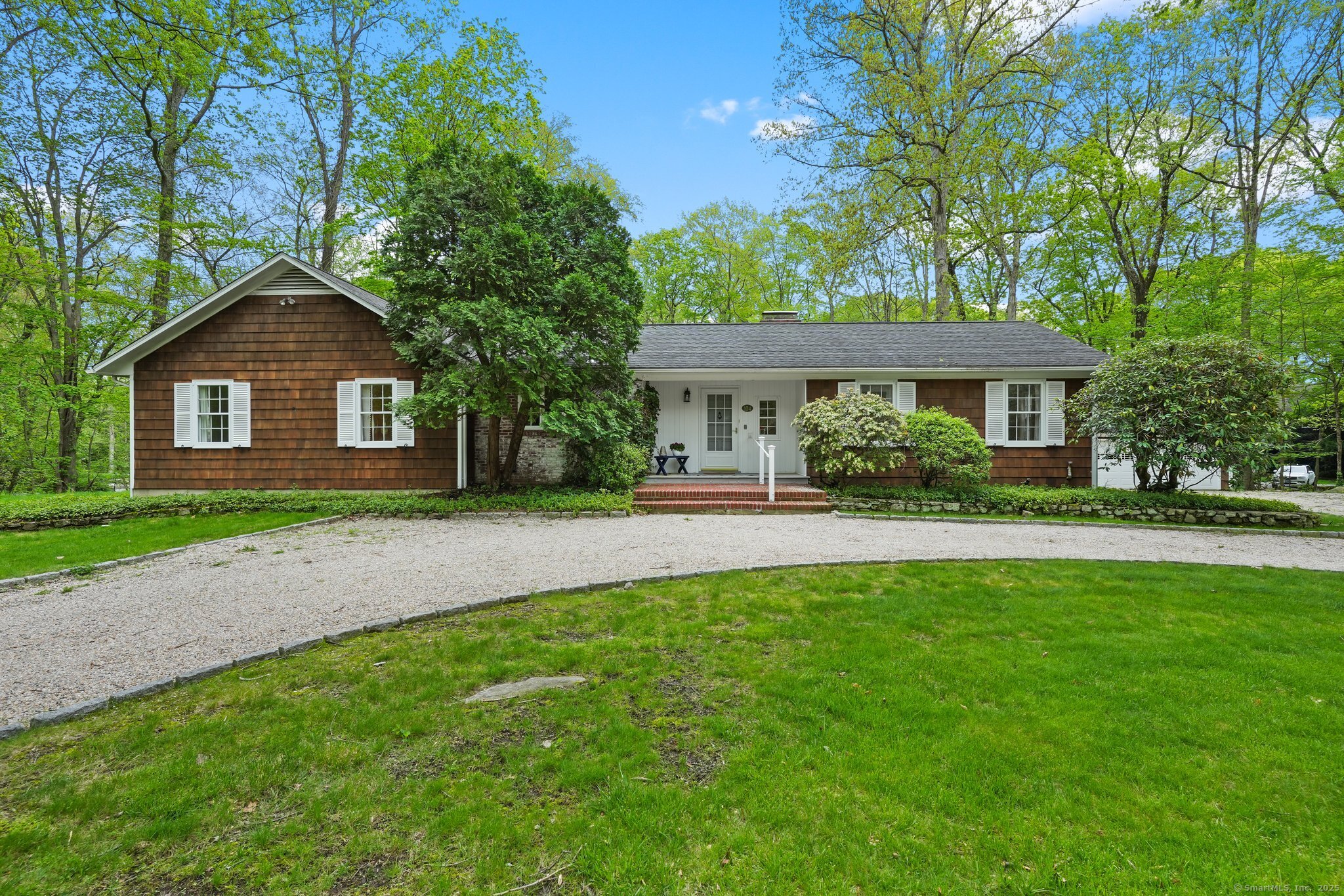 a front view of a house with a yard and green space