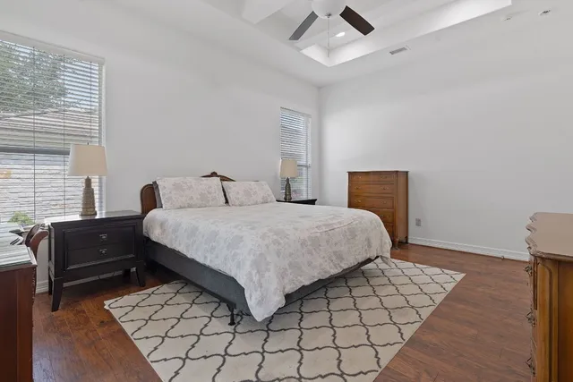 a bedroom with a bed and a dresser with wooden floor