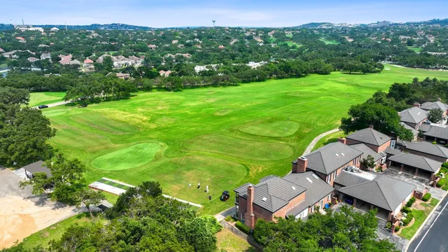 an aerial view of residential houses with outdoor space and trees