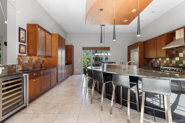 a kitchen with stainless steel appliances granite countertop table chairs stove and refrigerator