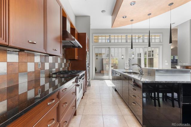 a kitchen with stainless steel appliances granite countertop a sink and a stove
