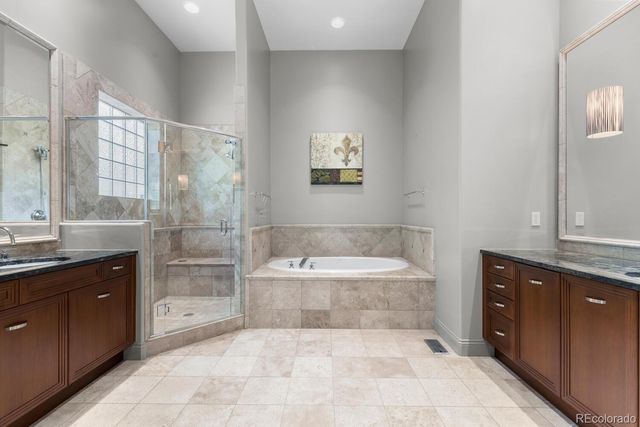 a spacious bathroom with a tub sink shower and mirror