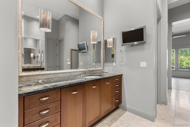 a bathroom with a granite countertop double vanity sink and a mirror