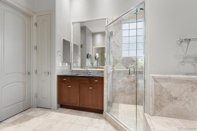 a bathroom with a granite countertop sink a mirror and shower