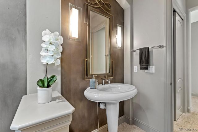 a bathroom with a sink a potted plant and a mirror