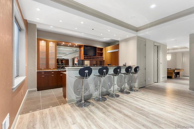 a view of a kitchen with kitchen island a counter top space a sink a refrigerator and a view of living room
