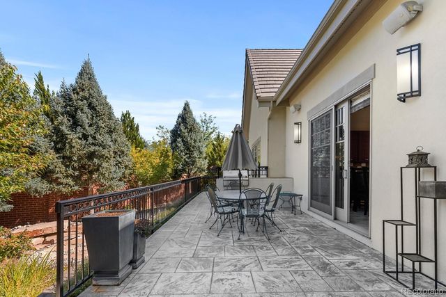 a roof deck with table and chairs and potted plants