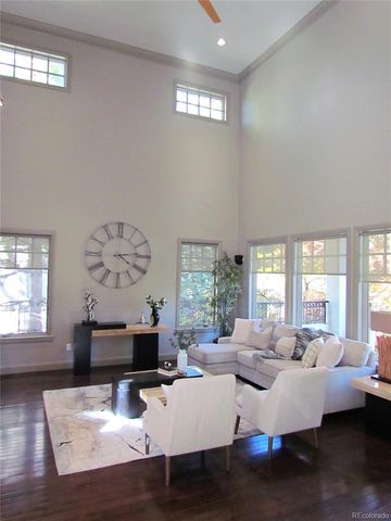 a living room with furniture large window and wooden floor
