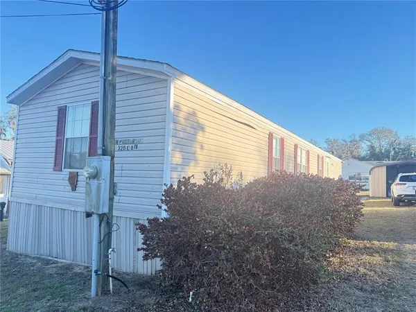 a view of a house with backyard and trees