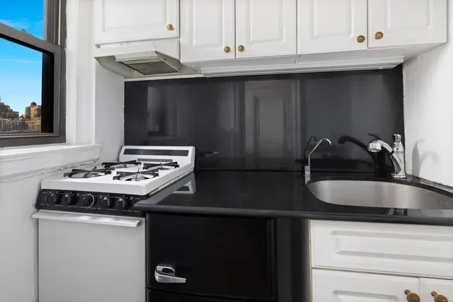 a kitchen with granite countertop a sink stainless steel appliances and cabinets