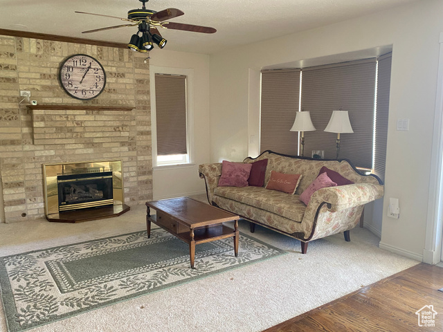 190 600 North Ferron, UT 84523 - Photo 6 of 85 Living room featuring ceiling fan, wood finished floors, a brick fireplace, and carpet