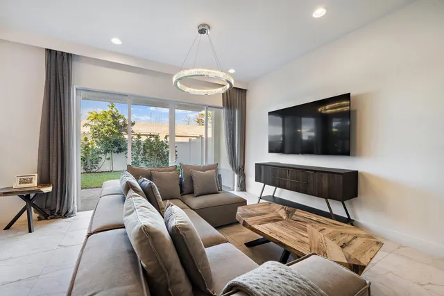 a living room with furniture ceiling fan and a flat screen tv