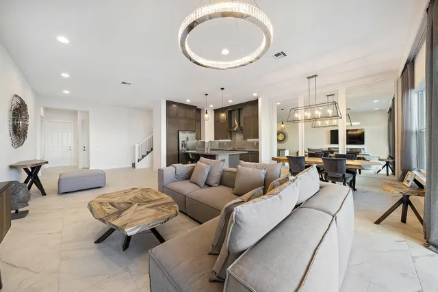 a living room with furniture and a dining table with wooden floor