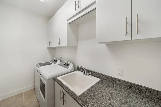 a utility room with sink dryer and washer