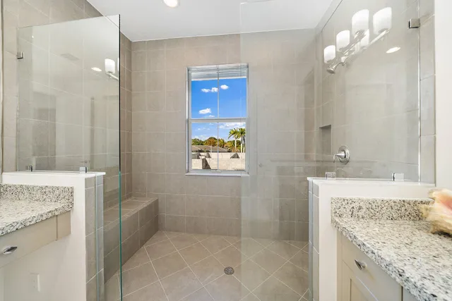 a bathroom with a granite countertop sink a mirror and a shower