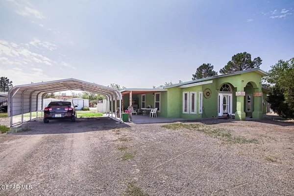 a view of a house with a yard and parking space