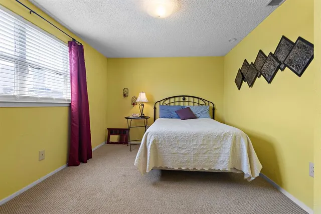 a bedroom with a bed and teddy bear on bed