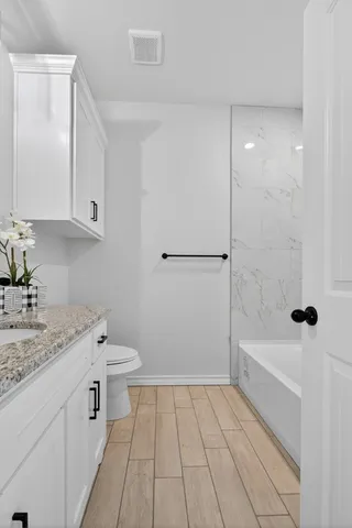 a bathroom with a sink a toilet and shower