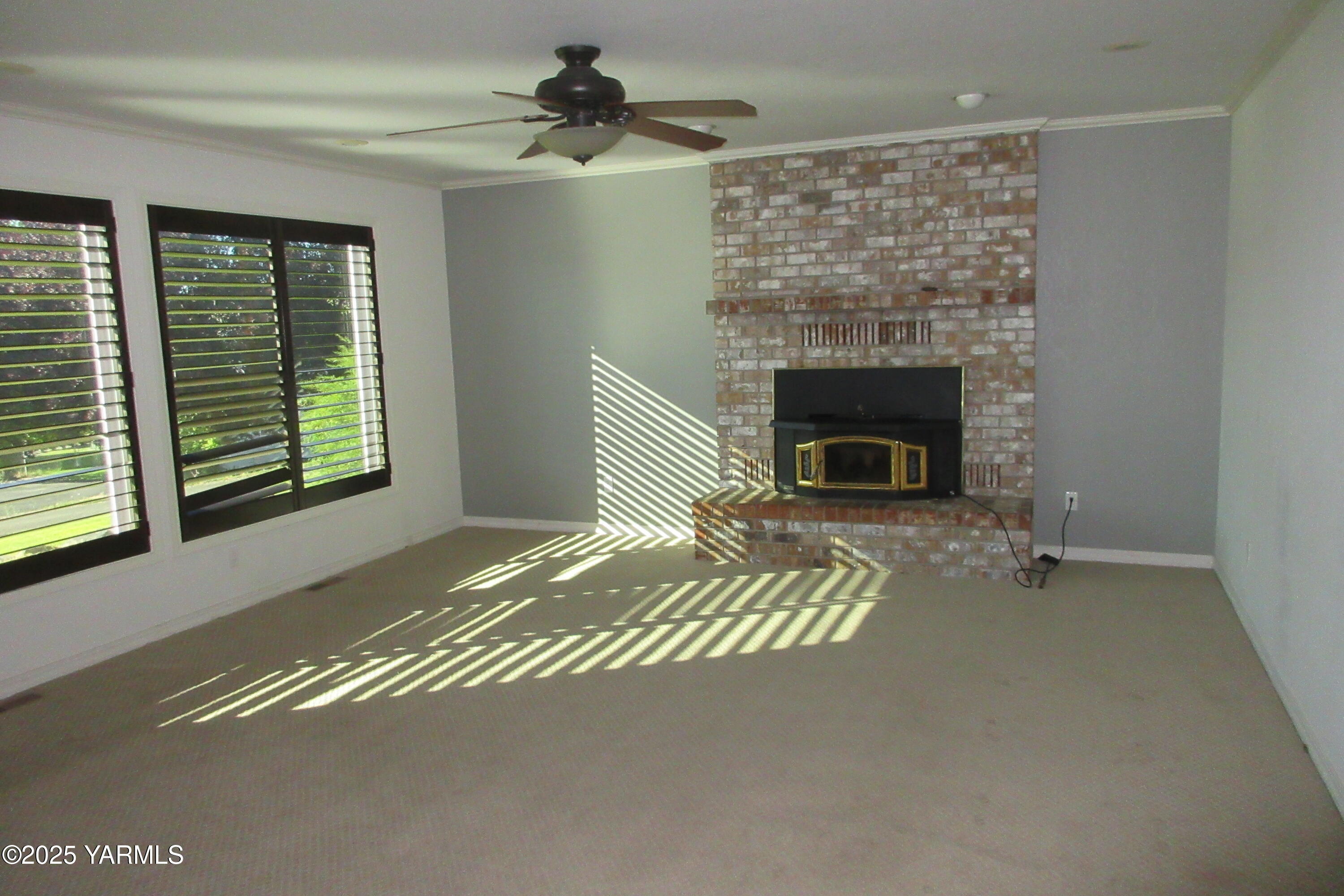 80 Hickory Lane Selah, WA 98942 - Photo 12 of 24 a living room with a fireplace furniture a ceiling fan and a window