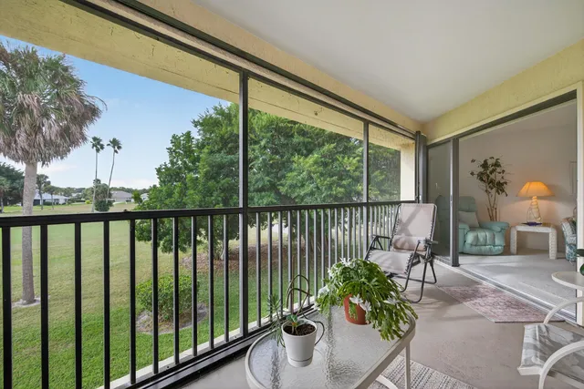a balcony with chairs and with potted plants
