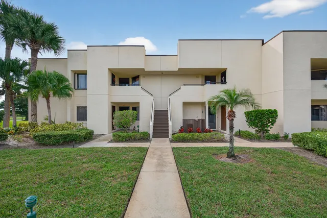 a front view of a house with potted plants