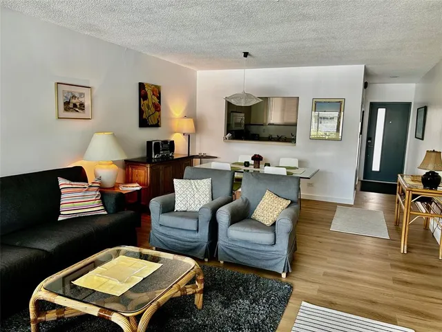 a living room with furniture flat screen tv and wooden floor
