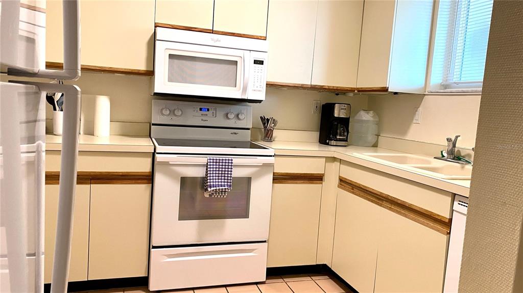 500 South Washington Drive, Unit 24B Sarasota, FL 34236 - Photo 24 of 25 a kitchen with stainless steel appliances granite countertop a sink and a microwave