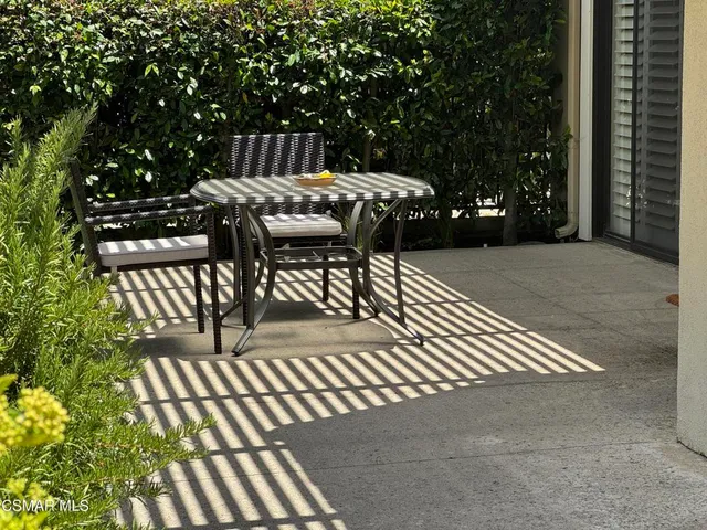 a view of a patio with a table and chairs with wooden floor and fence