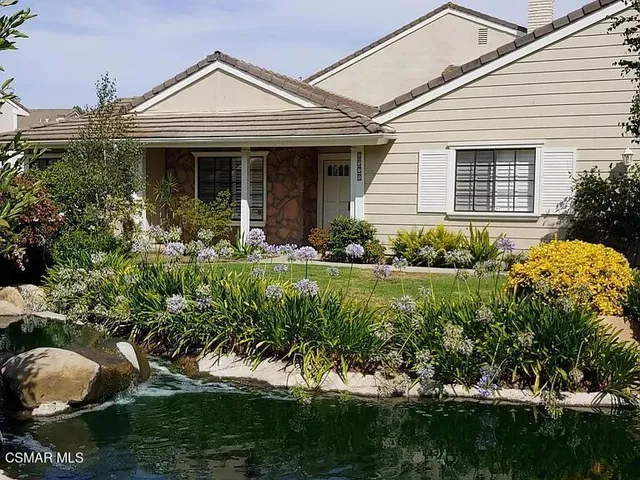a front view of a house with a yard and potted plants
