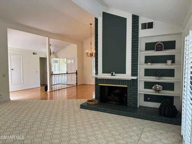 a view of a livingroom with wooden floor and a fireplace