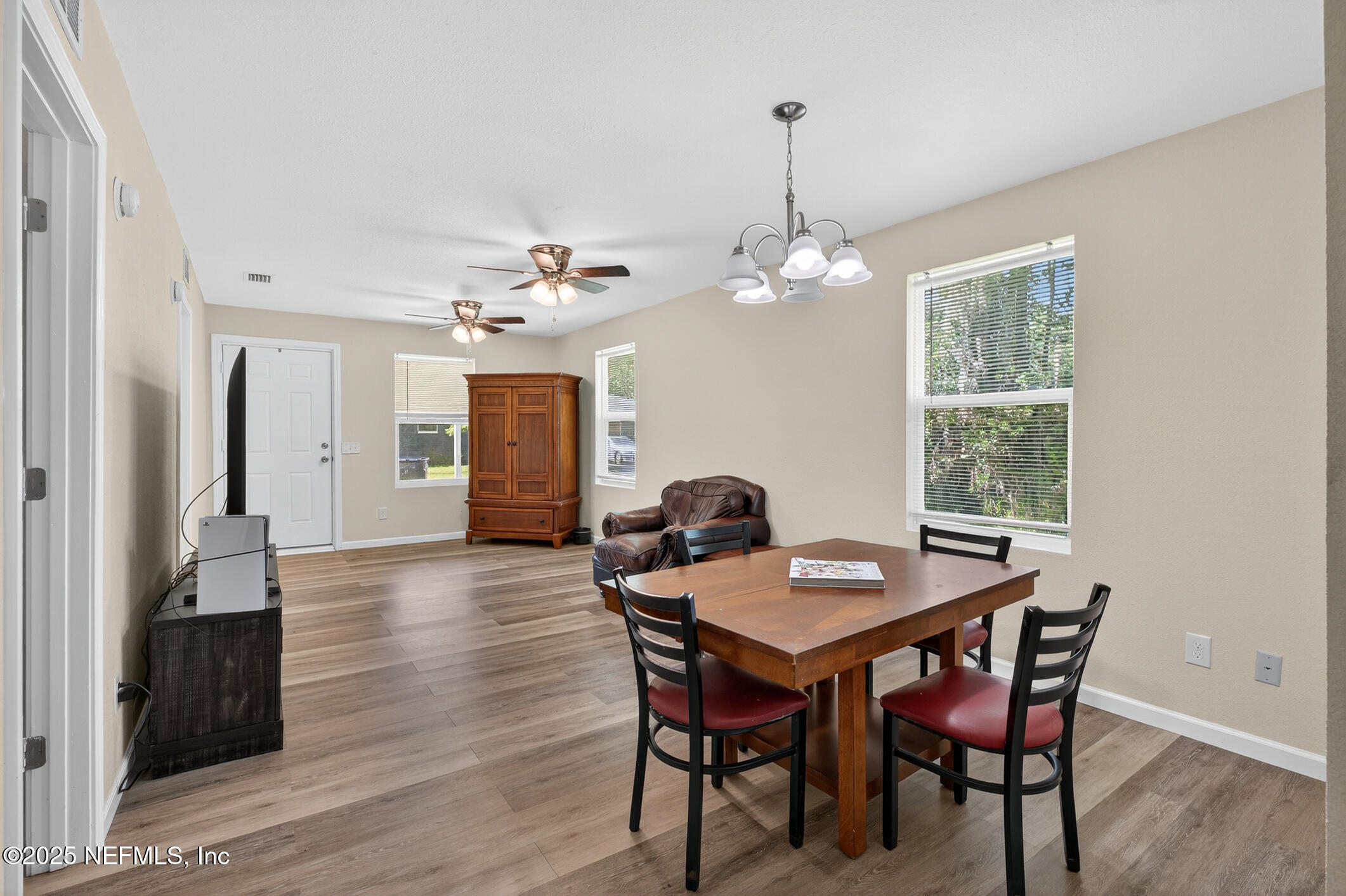 631 Moore Street Baldwin, FL 32234 - Photo 11 of 36 a dining room with wooden floor a chandelier a wooden table and chairs